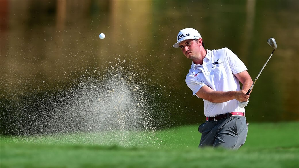 J.T. Poston hitting his Vokey Wedge out of a bunker.